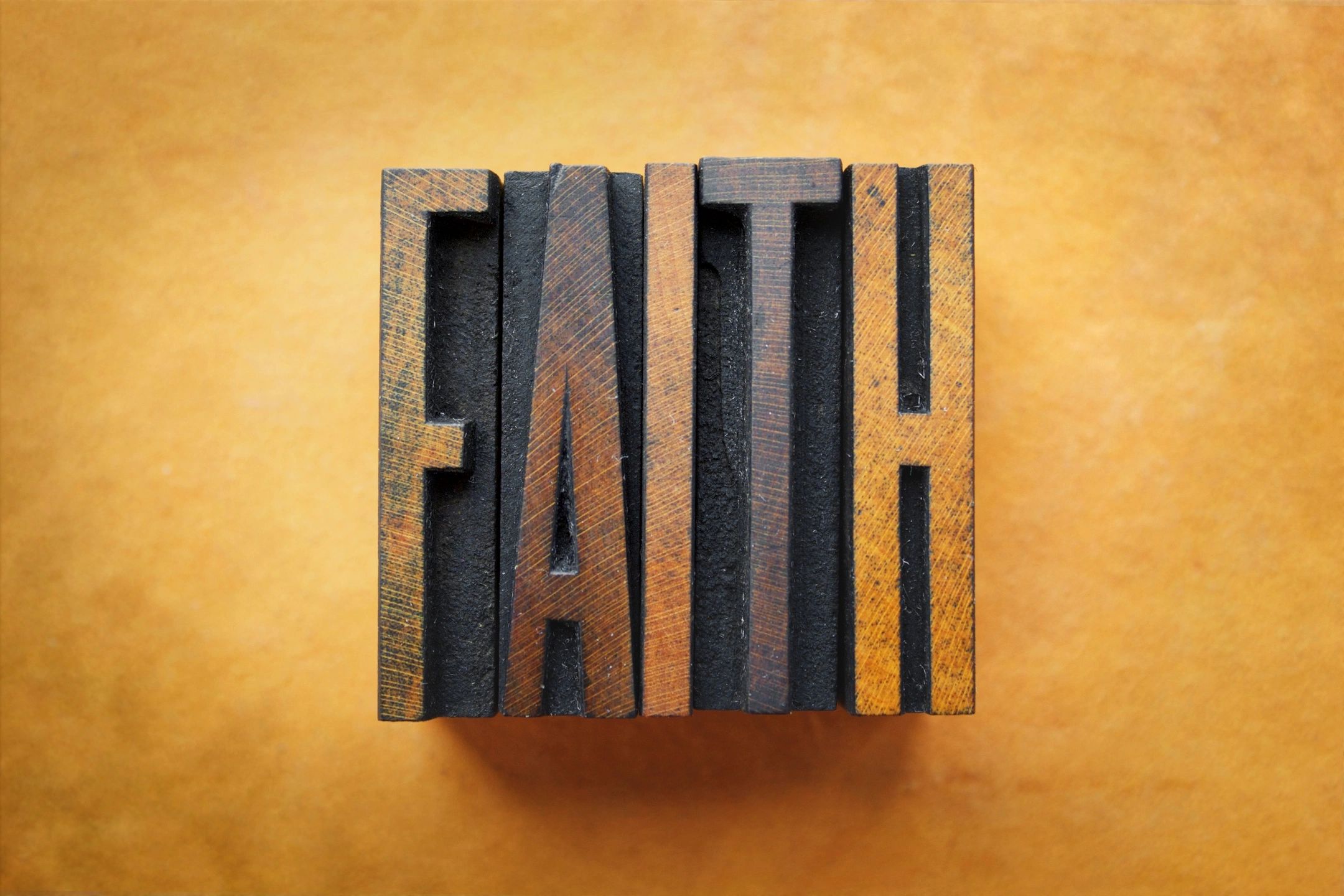 A wooden block that says " faith ".